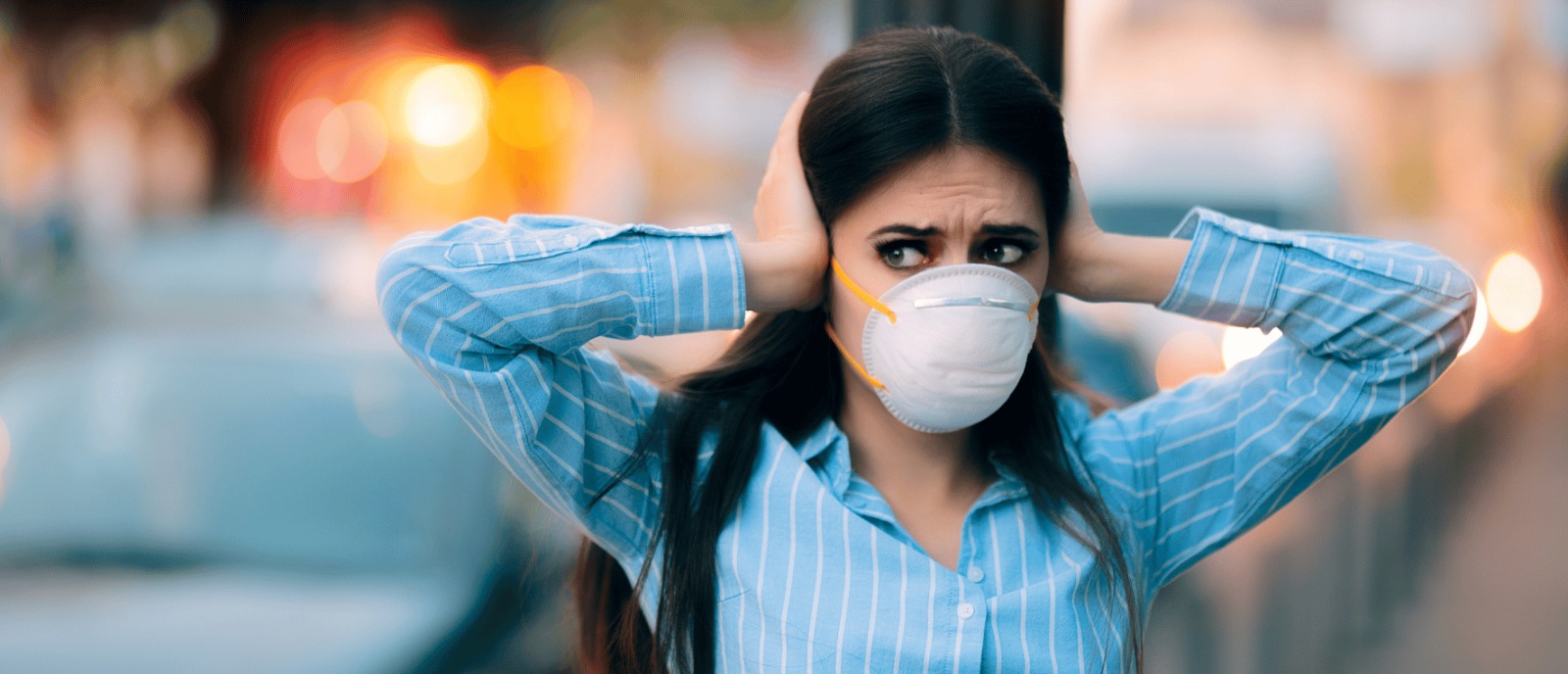 Protect Your Ears from Noise Pollution | Aanvii Hearing Person covering their ears from loud city noise, highlighting the dangers of noise pollution and ear protection – Aanvii Hearing.